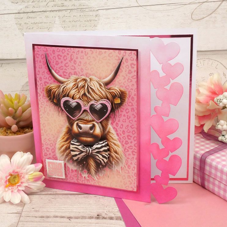 Fancy-Edge Blanks Hearts Edge decorative craft paper with a cow design and pink heart embellishments.